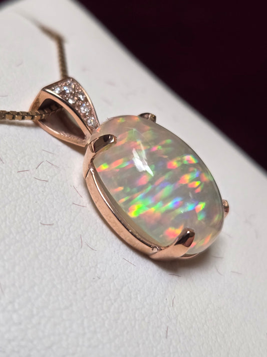 14K rose gold pendant featuring a 6ct oval opal gemstone, crafted by Chique Jewelry, with a delicate and elegant design.