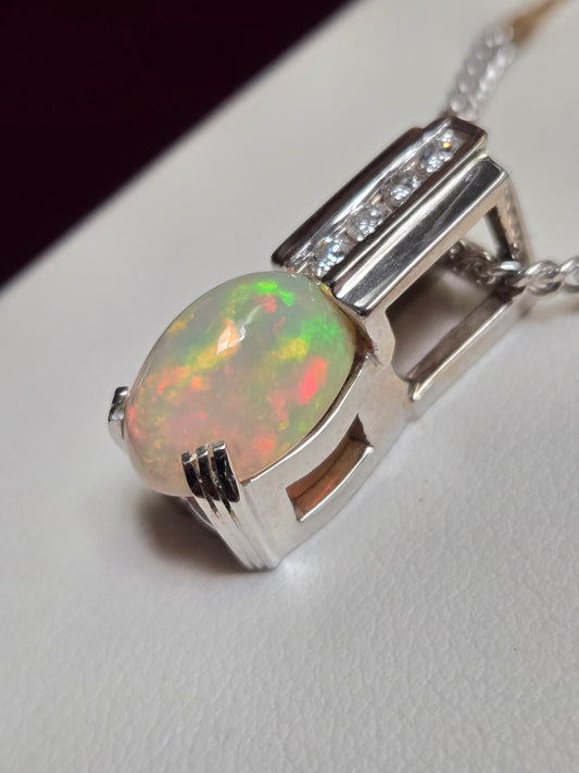 14K white gold pendant featuring an oval opal gemstone, weighing 4.8 grams, crafted by Chique Jewelry.