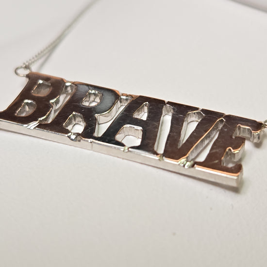 14K white gold diamond cut curb chain necklace with "Brave" pendant, 19-inch length, 3.2 grams from Chique Jewelry.