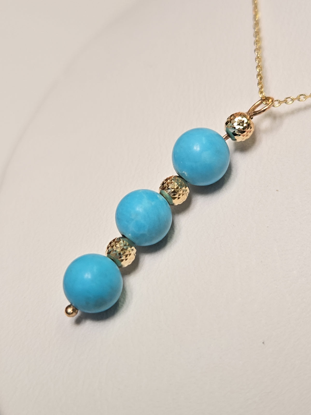 14K gold pendant necklace featuring a round turquoise stone, crafted by Chique Jewelry, weighs 1.6 grams.