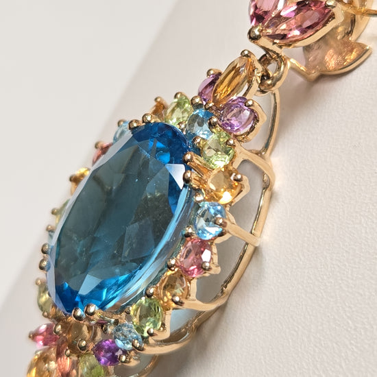14K gold pendant featuring an oval blue topaz gemstone, crafted by Chique Jewelry, weighing 7.8 grams.