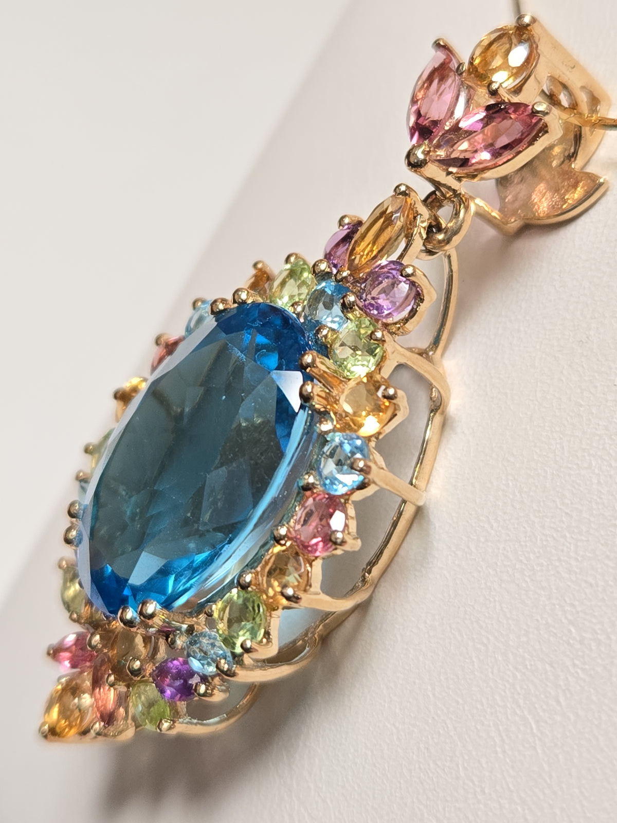 14K gold pendant featuring an oval blue topaz gemstone, crafted by Chique Jewelry, weighing 7.8 grams.