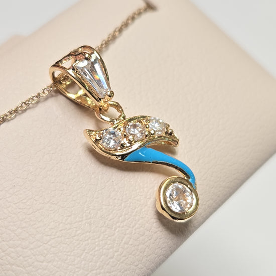 18K gold pendant with cubic zirconias from Chique Jewelry, showcasing a sparkling jewelry piece on a neutral background.