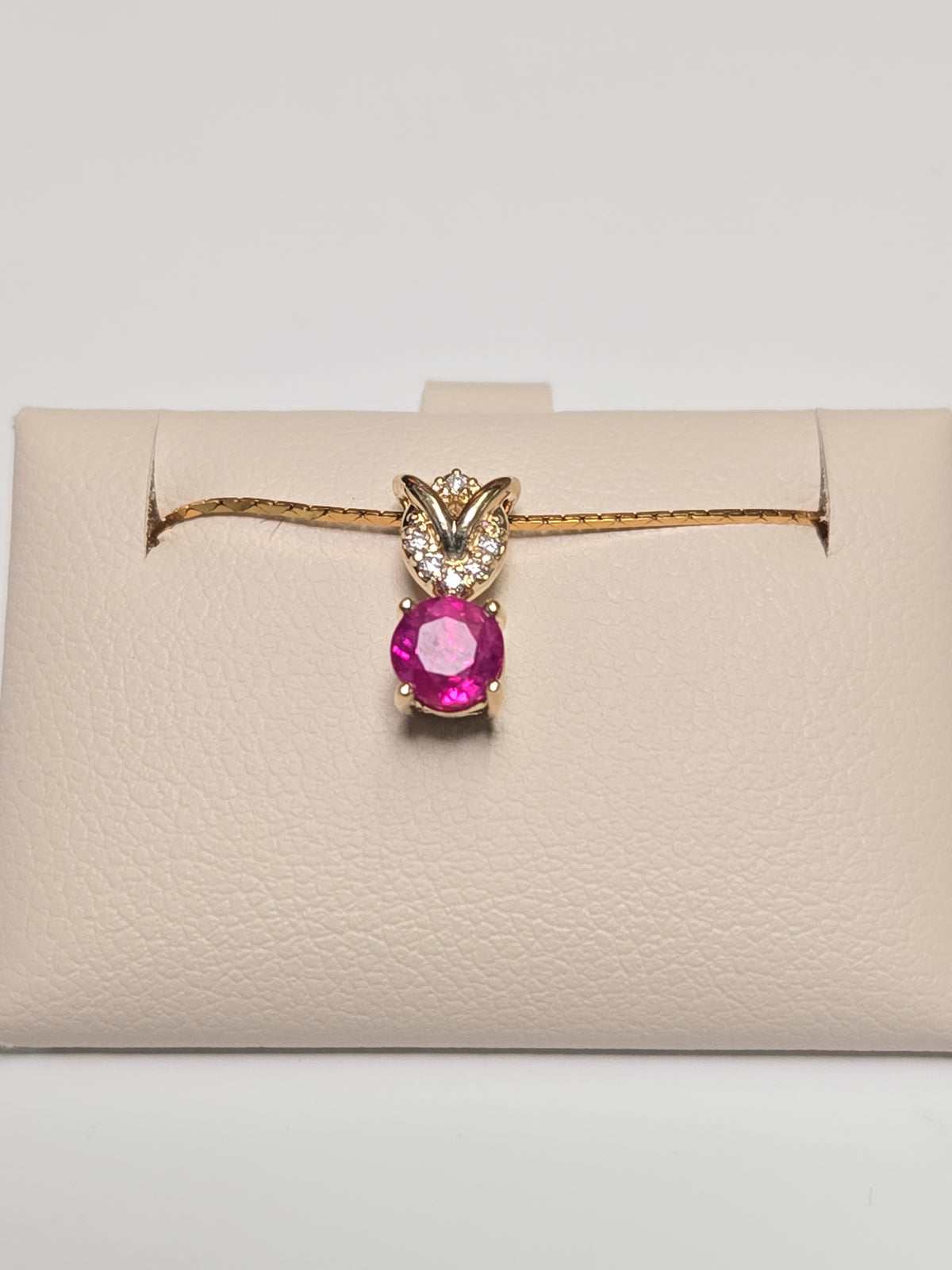 14K gold pendant featuring a 0.67ct round ruby, weighing 0.8g, from Chique Jewelry.