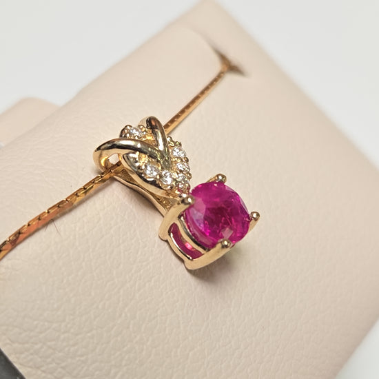 14K gold pendant featuring a 0.67ct round ruby and delicate design, weighing 0.8g, from Chique Jewelry.
