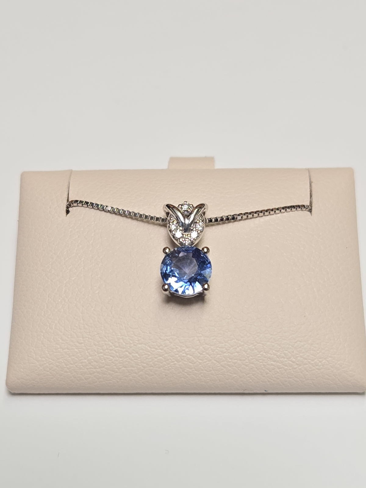 14K white gold pendant featuring a 0.72ct round sapphire, from Chique Jewelry, with a delicate and elegant design.