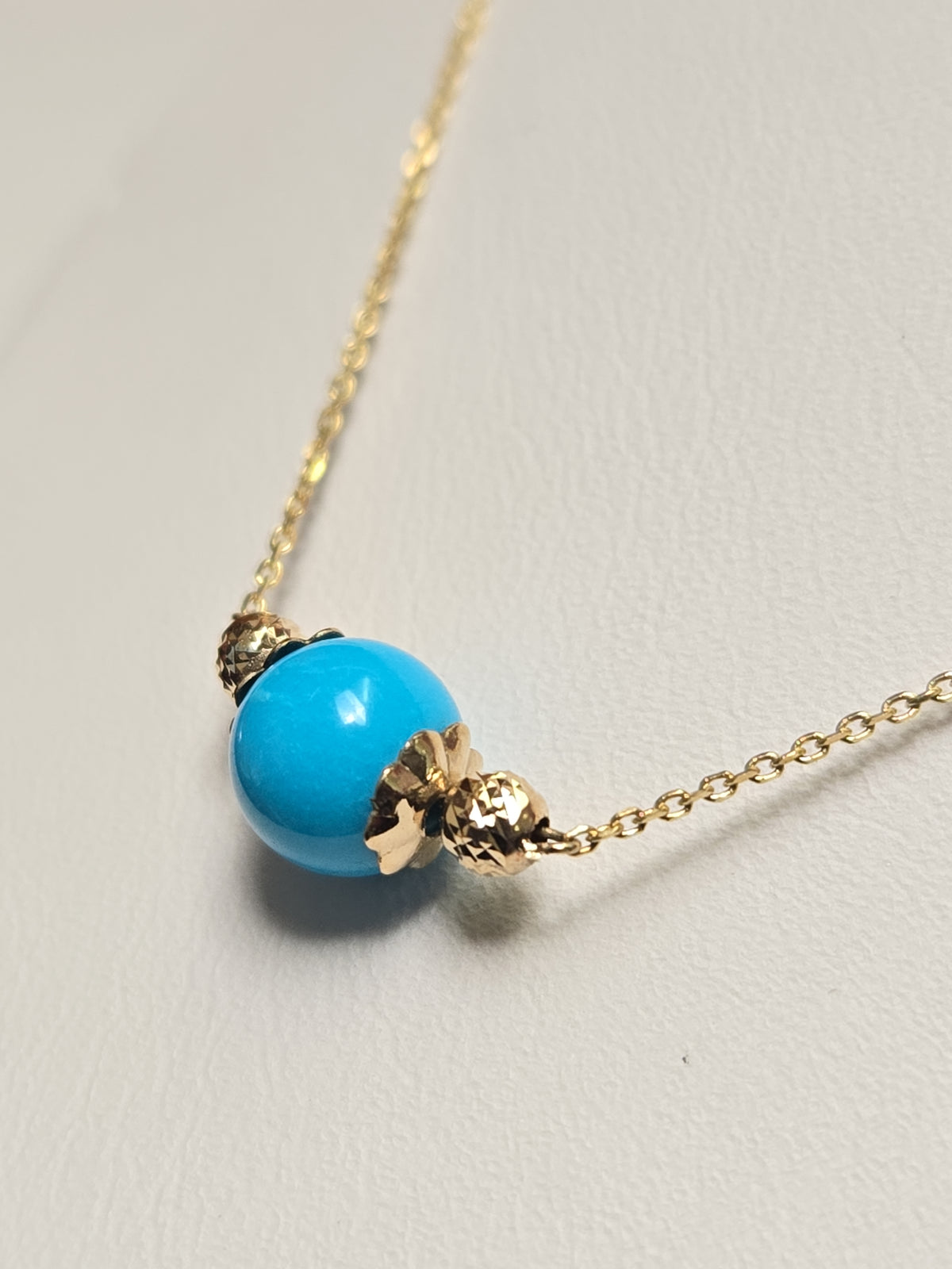 14K gold pendant necklace with round turquoise gemstone, featuring a delicate Chique Jewelry design.