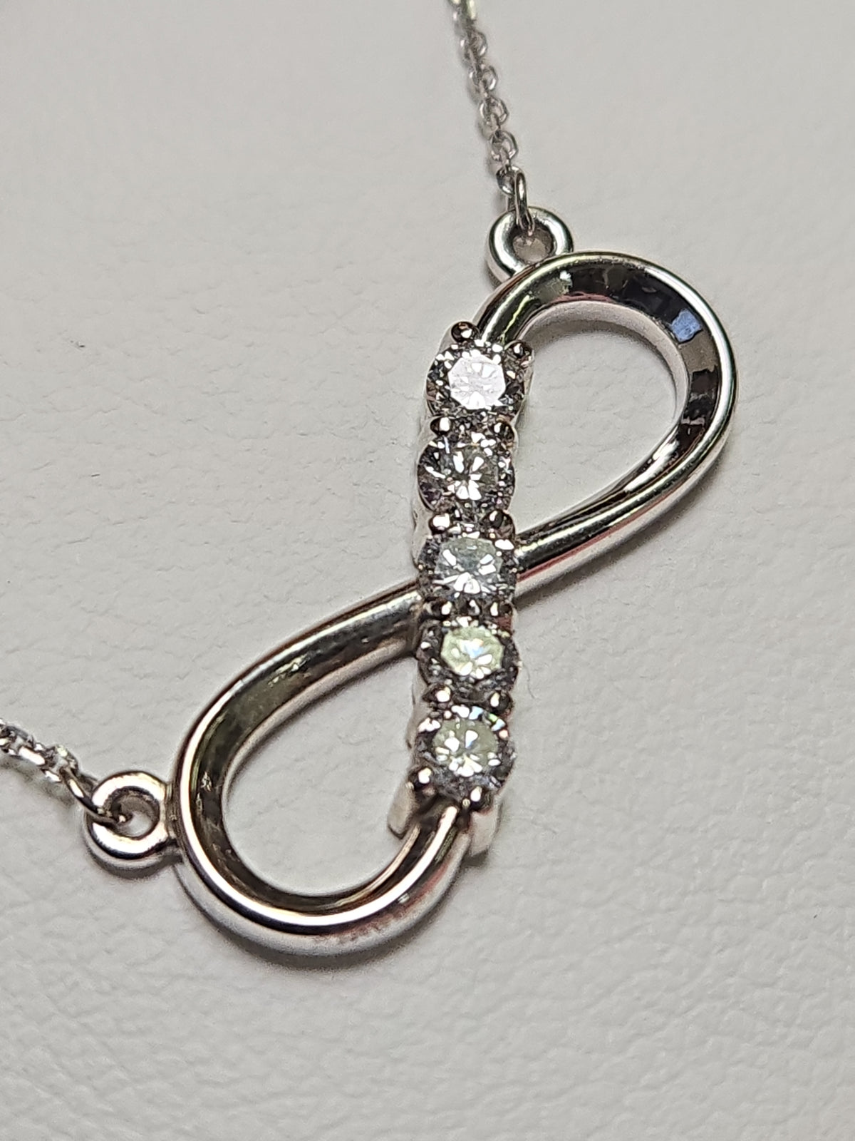 14K white gold infinity pendant necklace with lab-created diamonds, weighing 2.9g, from Chique Jewelry.