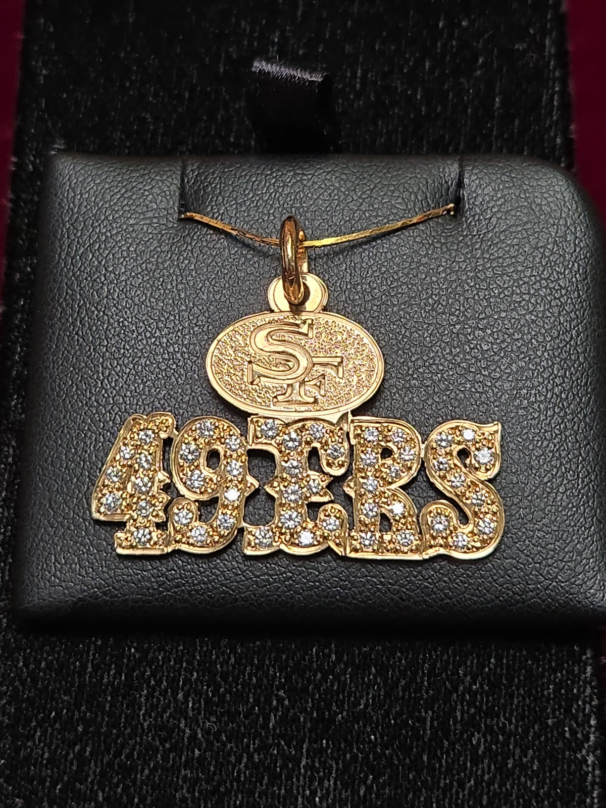 14K gold 49ers pendant with 1.1ct round diamond, crafted by Chique Jewelry, featuring a detailed sports team design.