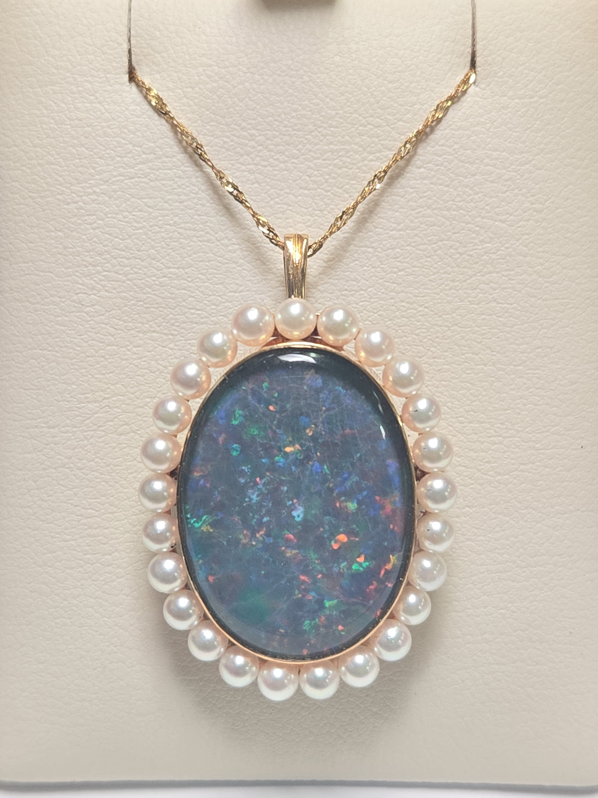 18K gold brooch pendant with oval doublette opal, crafted by Chique Jewelry, featuring a polished gold setting and elegant design.