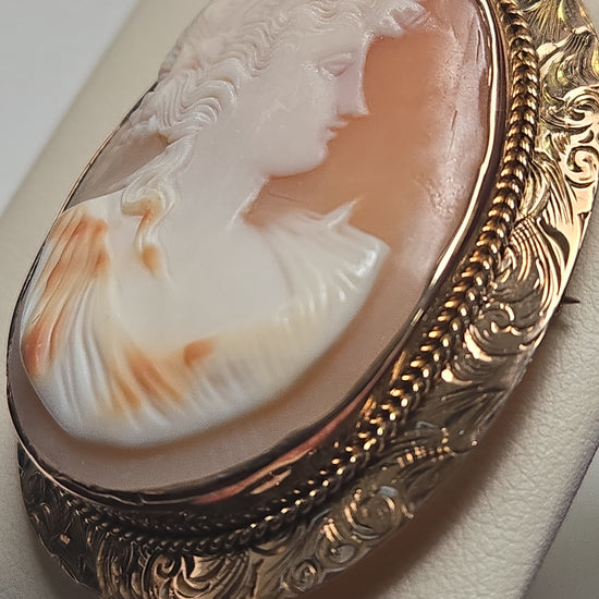 14K gold cameo brooch pendant with detailed carved design, weighing 10g, by Chique Jewelry, shown in close-up detail.