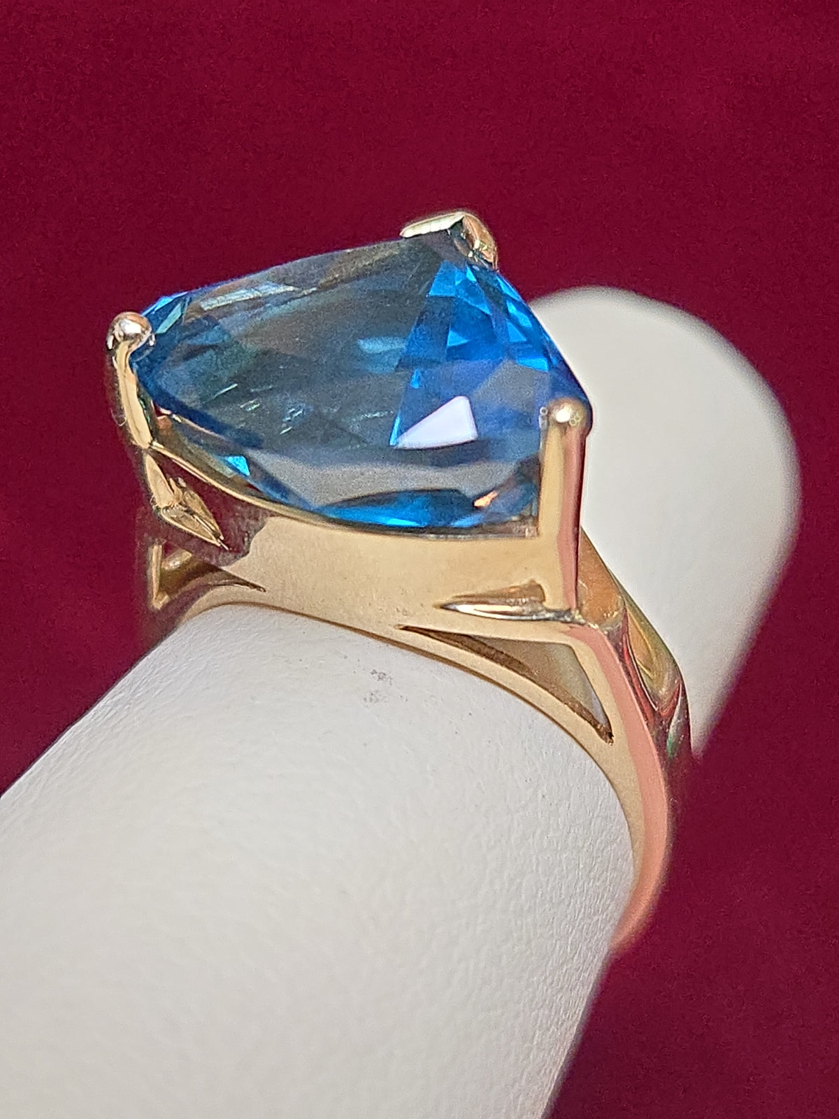 14K gold-colored stone ring featuring a trillion-shaped blue topaz, accented with elegant design details.