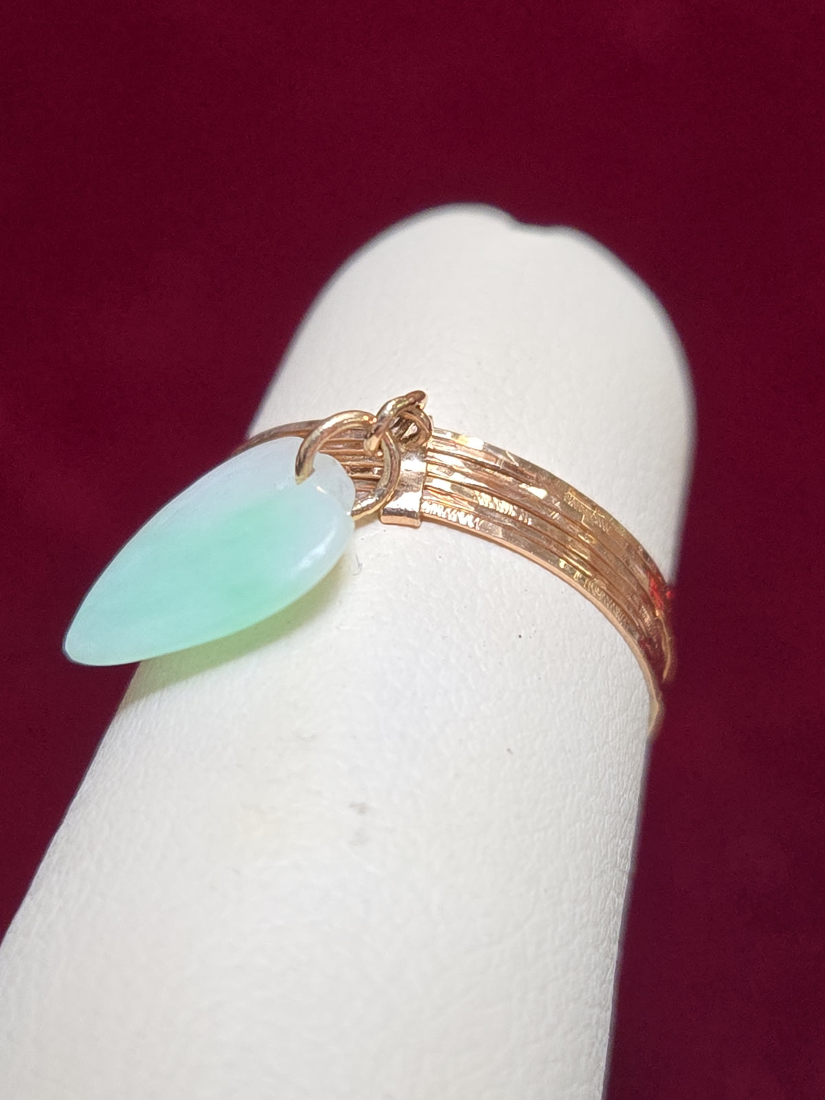 14K rose gold charm ring with a pear-shaped jade gemstone, weighing 1.1 grams, by Chique Jewelry.