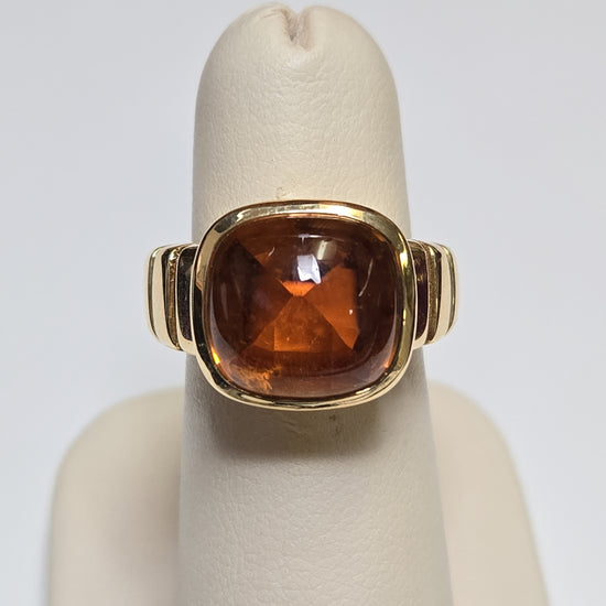 Van Cleef 18K gold ring with a large cabochon citrine gemstone, showcasing elegant jewelry craftsmanship.