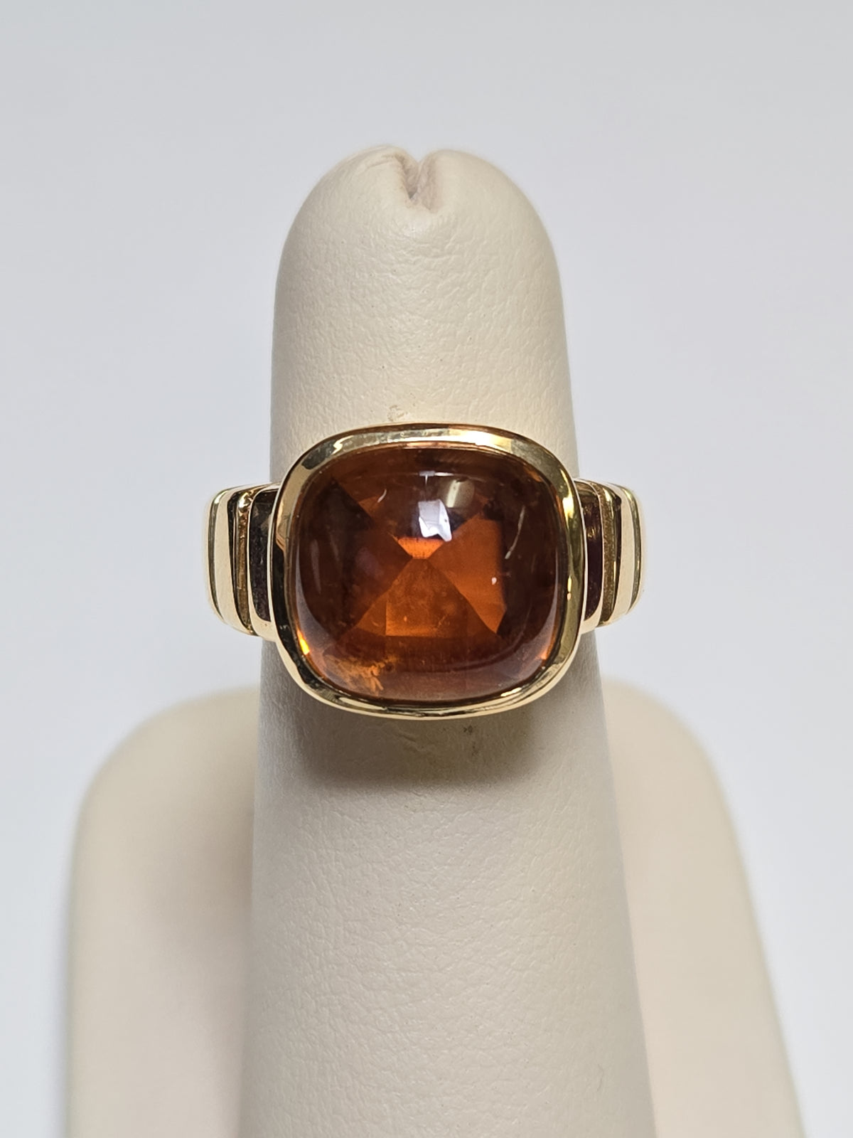 Van Cleef 18K gold ring with a large cabochon citrine gemstone, showcasing elegant jewelry craftsmanship.