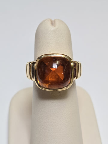 Van Cleef 18K gold ring with a large cabochon citrine gemstone, showcasing elegant jewelry craftsmanship.