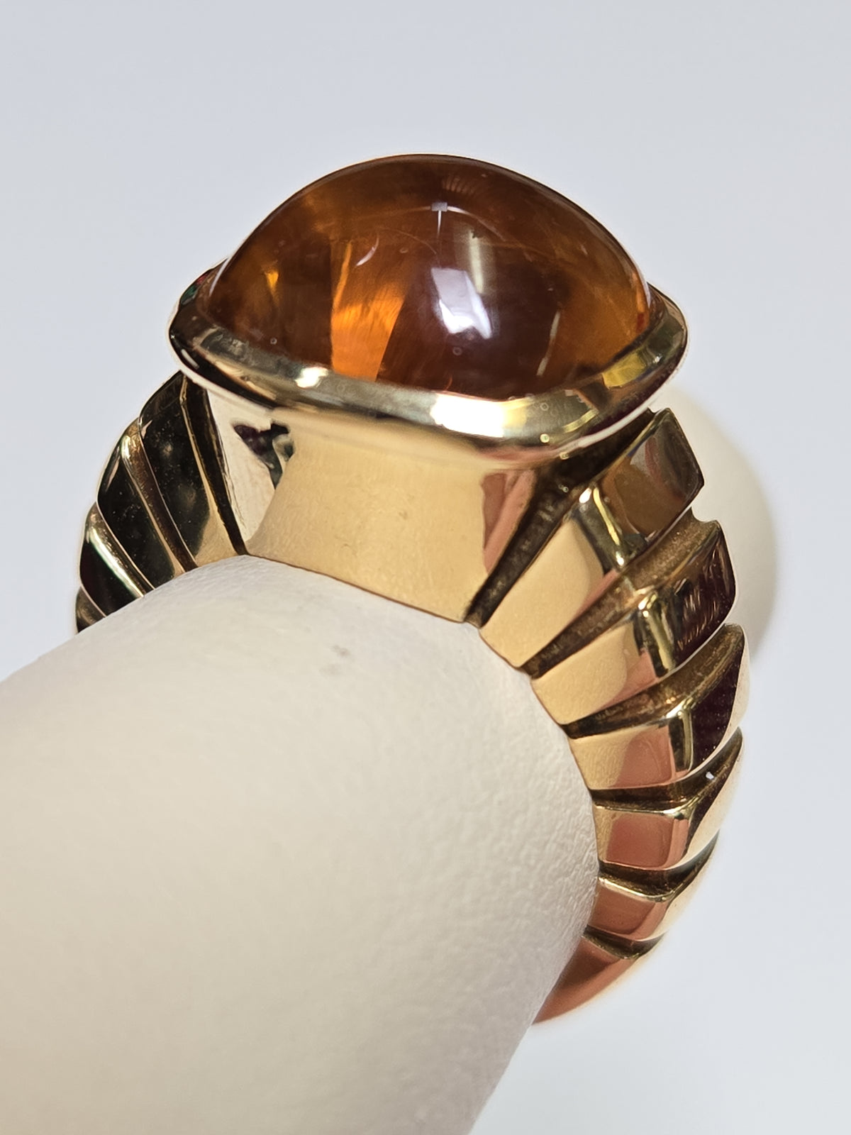 Van Cleef 18K gold ring with a cabochon citrine gemstone, showcasing elegant jewelry design and craftsmanship.