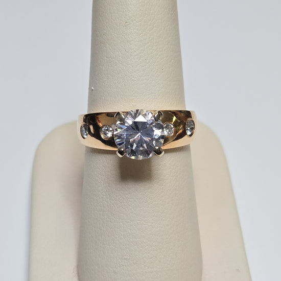 14K gold ring with round cubic zirconia stone, designed by Chique Jewelry, showcasing a polished band and sparkling centerpiece.