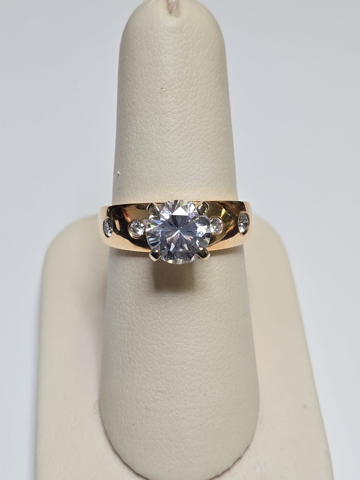 14K gold ring with round cubic zirconia stone, designed by Chique Jewelry, showcasing a polished band and sparkling centerpiece.