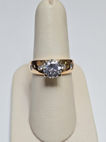 14K gold ring with round cubic zirconia stone, designed by Chique Jewelry, showcasing a polished band and sparkling centerpiece.