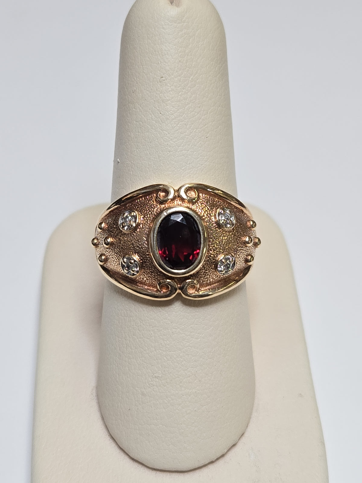 10K gold ring featuring a 1-carat oval garnet gemstone, crafted by Chique Jewelry, with a sleek and elegant design.