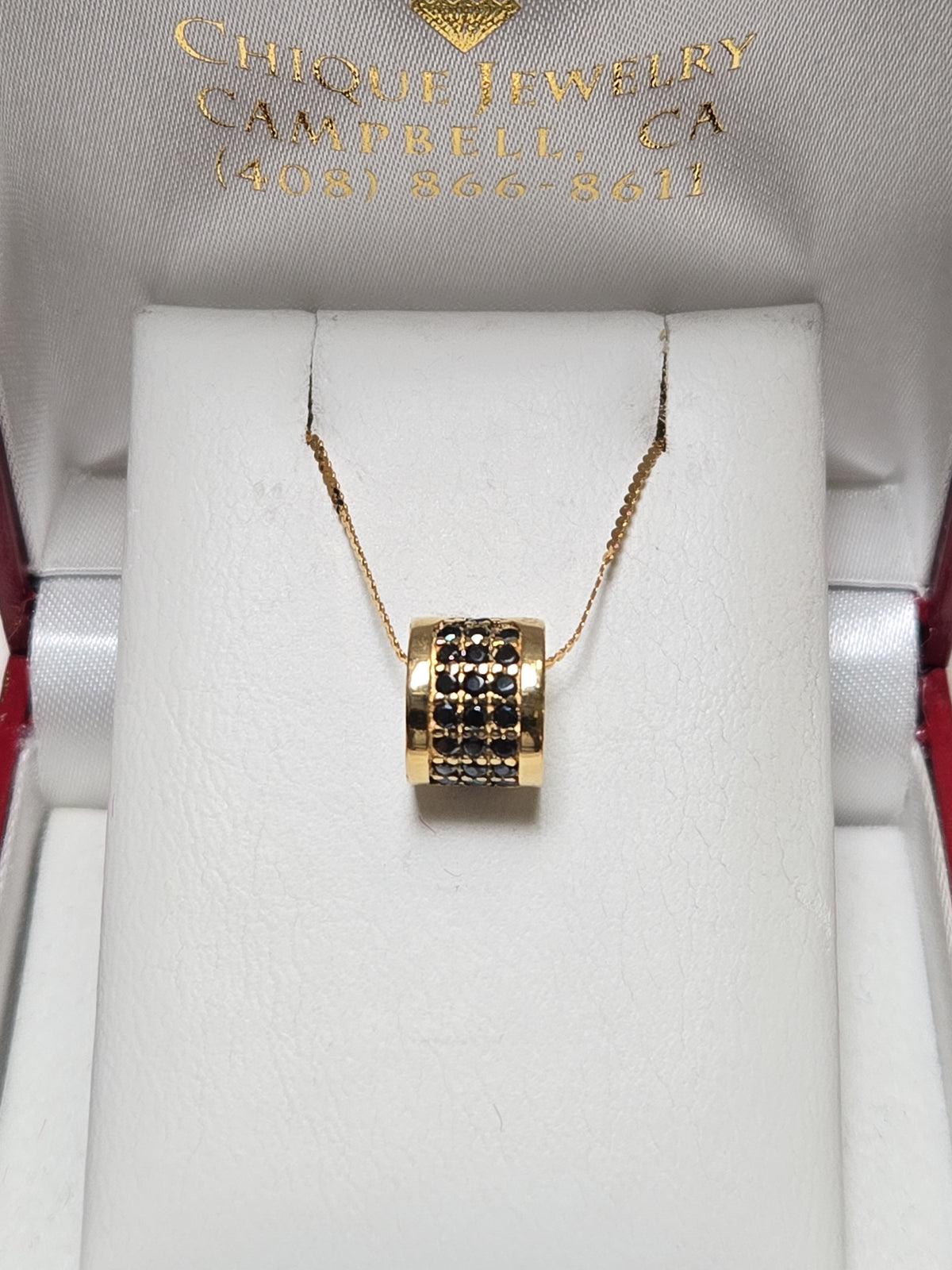 Bulgari 18K gold pendant with 0.5ct round black diamonds, elegant jewelry piece showing the pendant's detailed design.