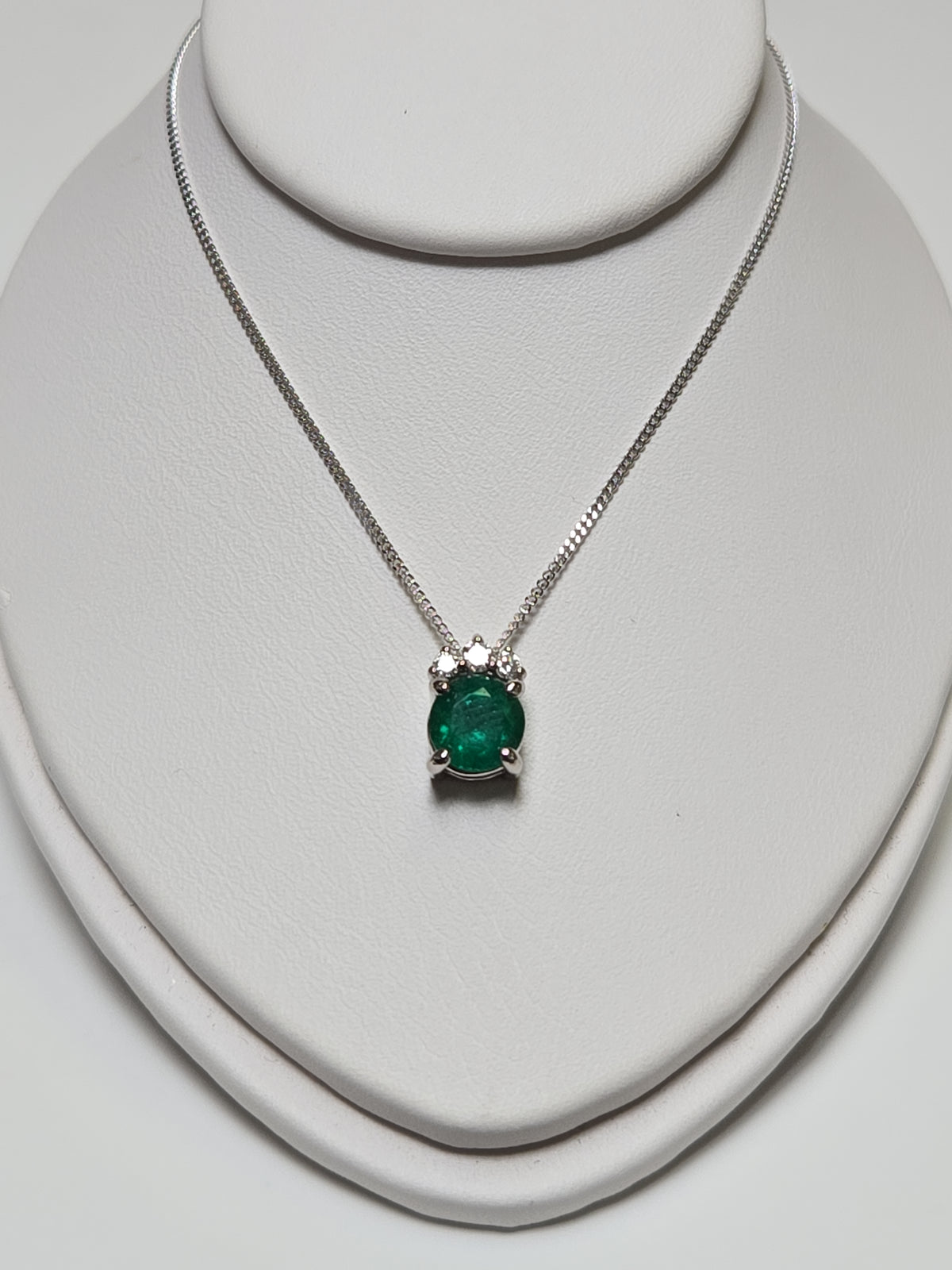 14K white gold pendant necklace featuring a 0.83ct oval emerald gemstone, crafted by Chique Jewelry.