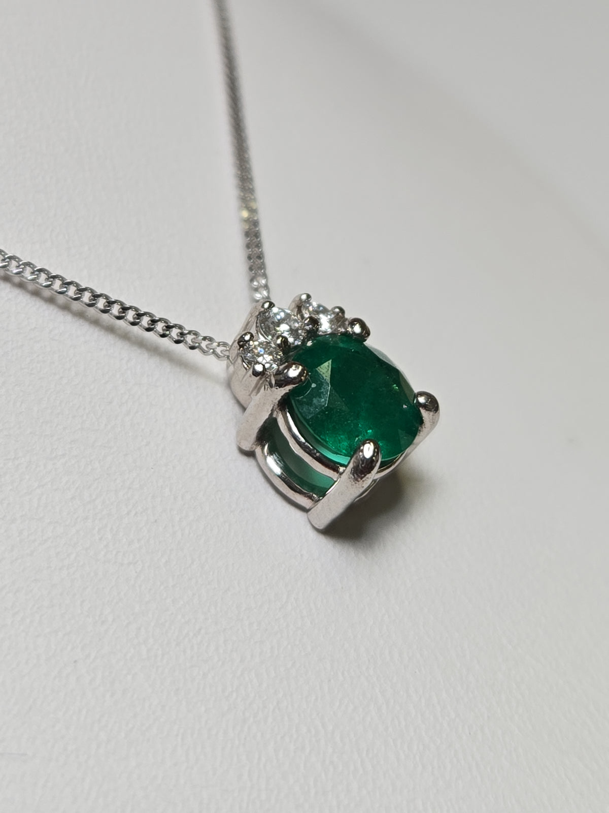 14K white gold pendant necklace with a 0.83ct oval emerald, featuring a elegant jewelry design by Chique Jewelry.