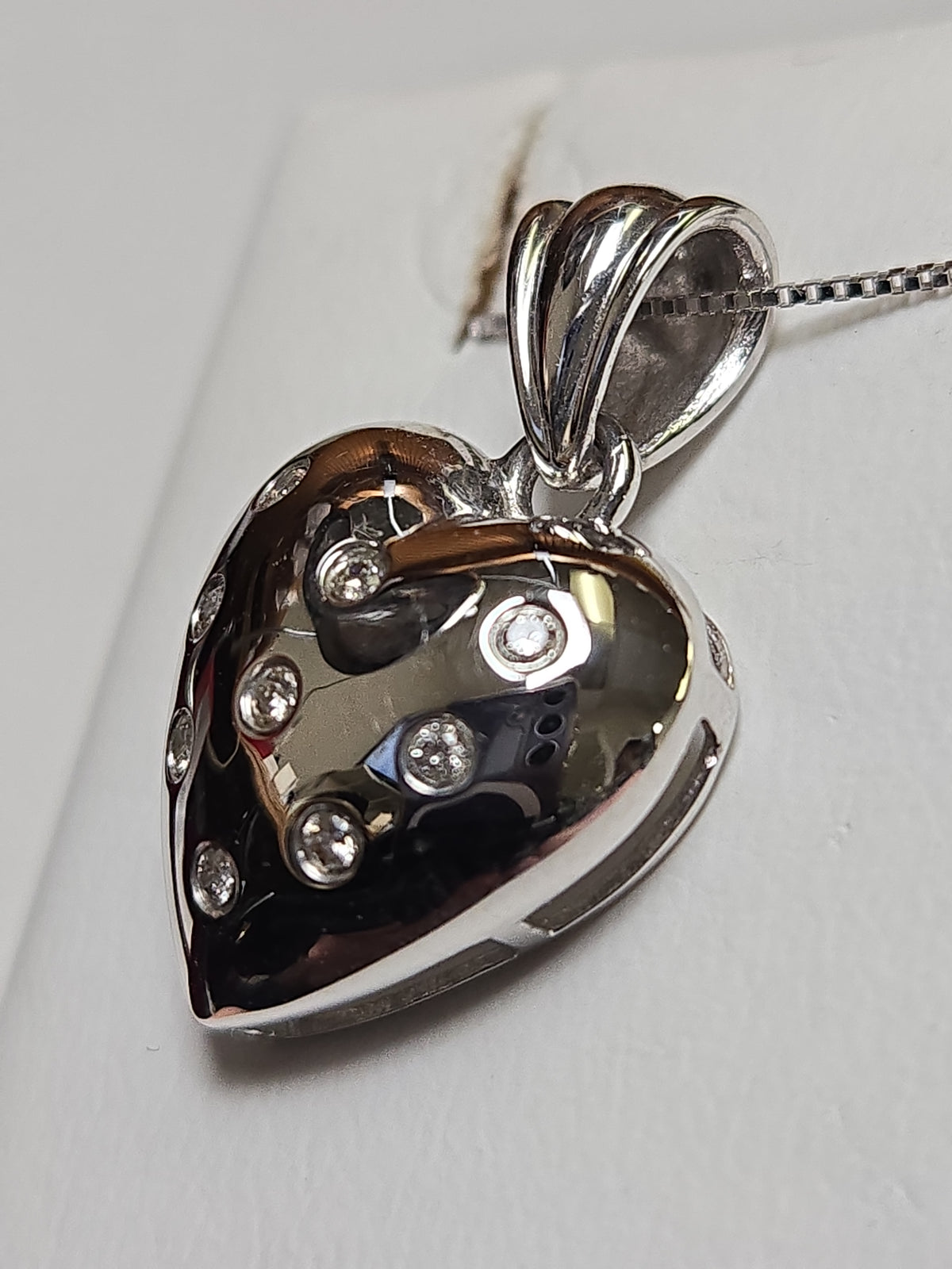 14K white gold heart pendant with 0.14ct round diamonds, elegant jewelry piece by Chique Jewelry, weighs 3 grams.