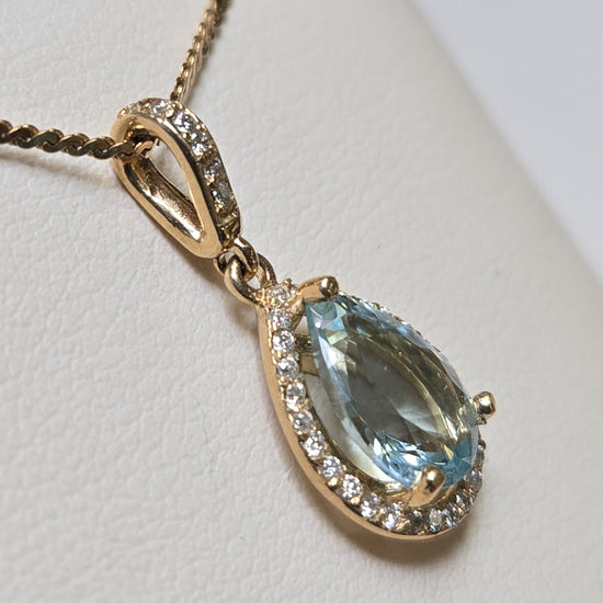 14K gold pendant featuring a 1.5ct pear-shaped aquamarine gemstone, set in a delicate jewelry design by Chique Jewelry.