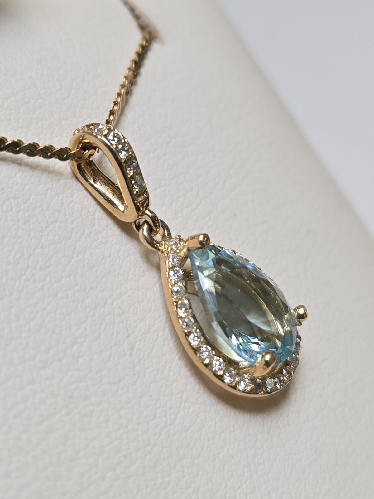 14K gold pendant featuring a 1.5ct pear-shaped aquamarine gemstone, set in a delicate jewelry design by Chique Jewelry.