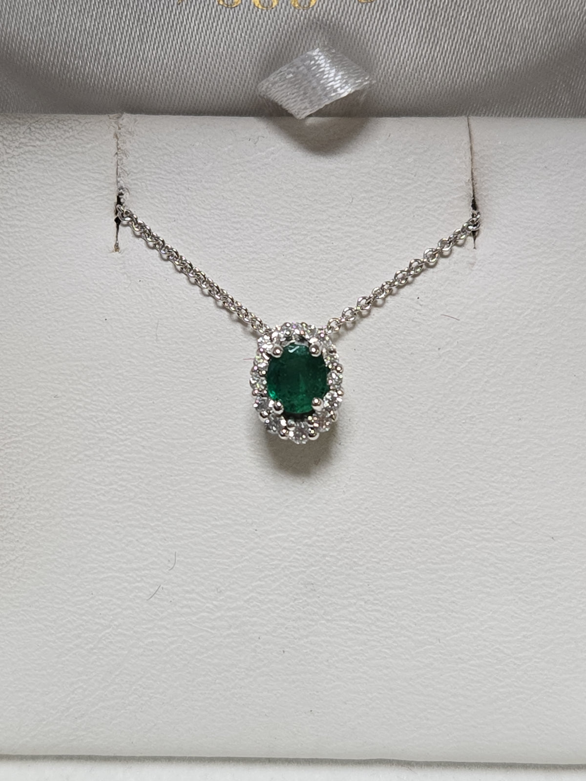 14K white gold pendant with a 0.4ct oval emerald gemstone, weighing 0.8 grams, by Chique Jewelry.