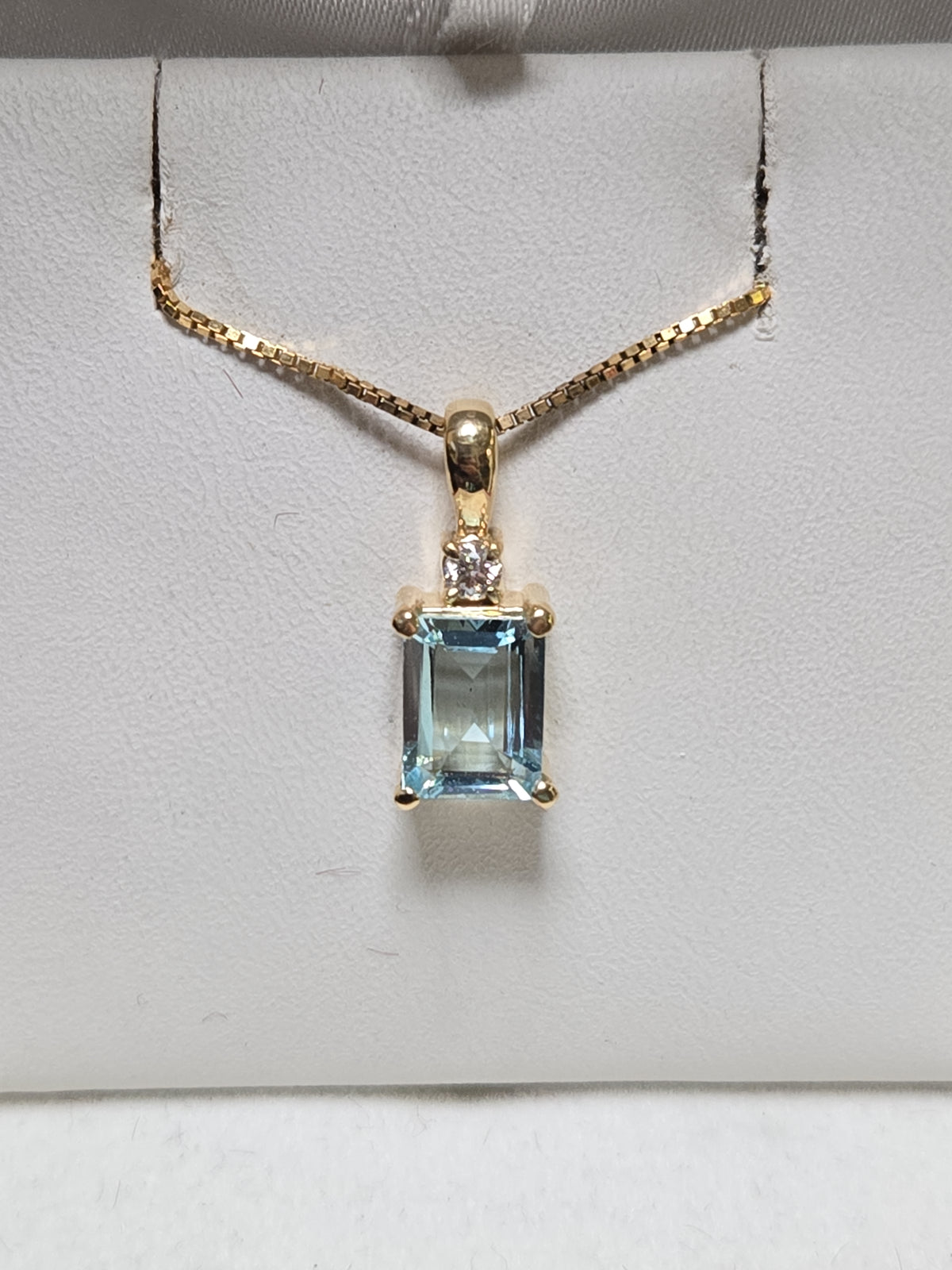 14K gold pendant featuring a large emerald-cut aquamarine gemstone, weighing 1.7 grams, from Chique Jewelry.