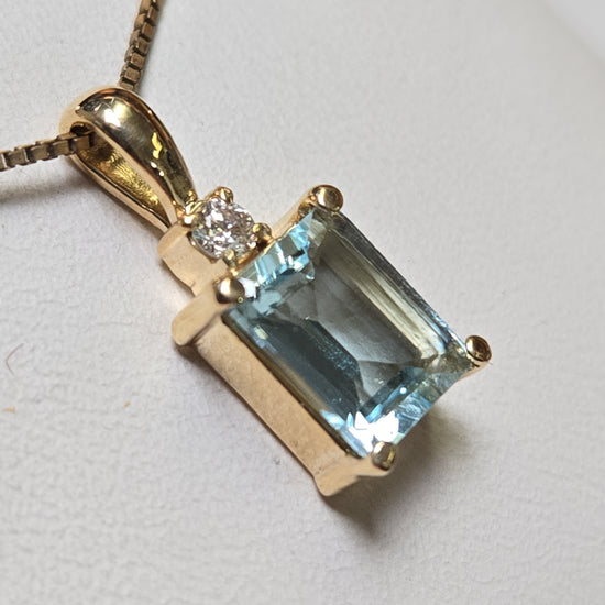 14K gold pendant featuring an emerald-cut aquamarine gemstone, weighing 1.7g, from Chique Jewelry.