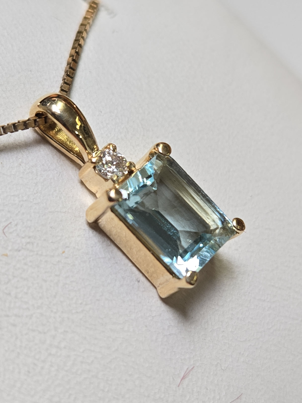 14K gold pendant featuring an emerald-cut aquamarine gemstone, weighing 1.7g, from Chique Jewelry.