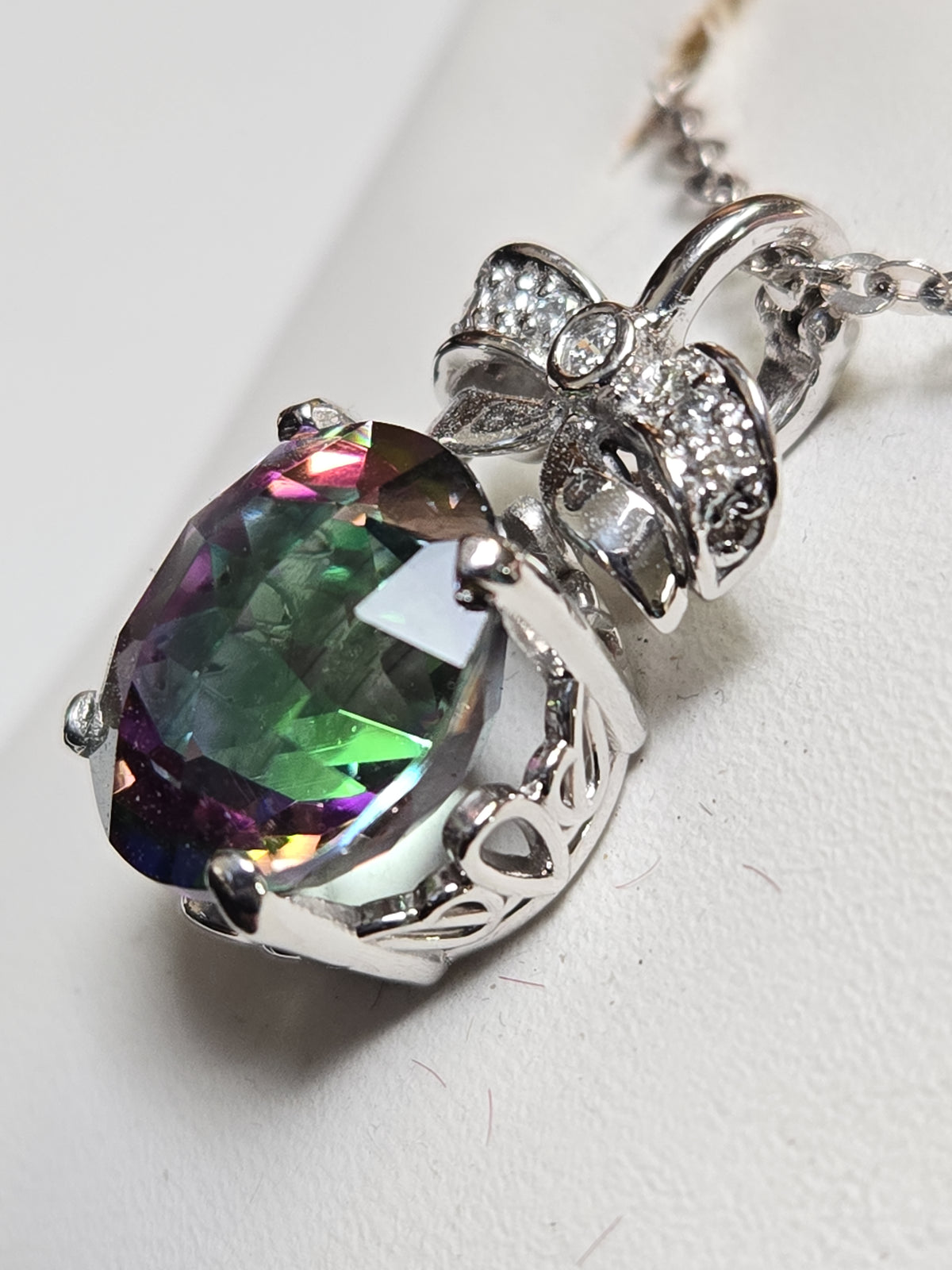 14K white gold pendant featuring a round treated mystic topaz gemstone, weighing 4.5 grams, from Chique Jewelry.
