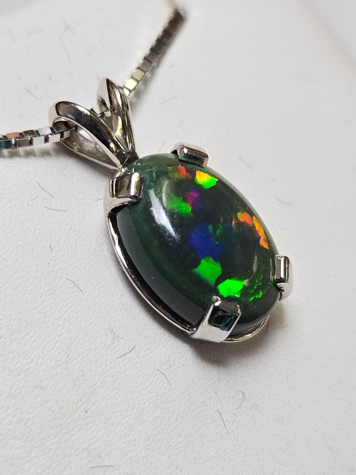 14K white gold pendant featuring an oval opal gemstone from Chique Jewelry, showcasing a sleek and elegant jewelry design.