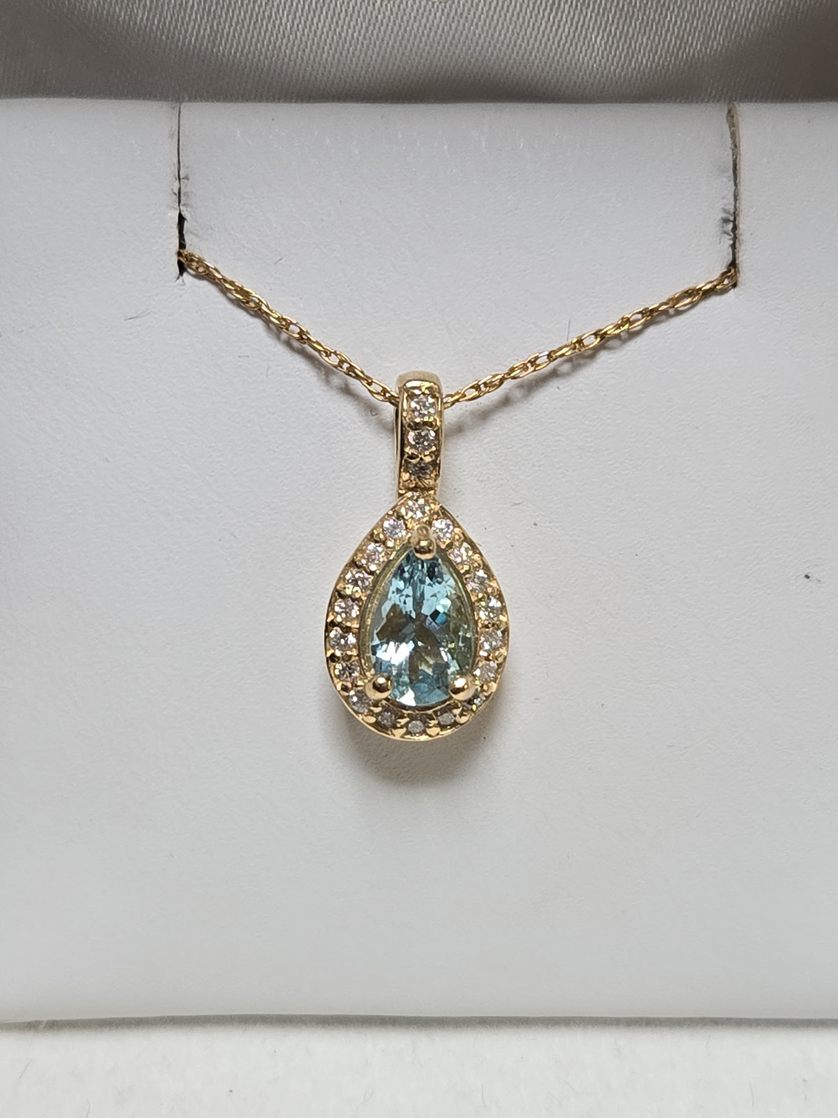 14K gold pendant featuring a 0.78ct pear-shaped aquamarine, displayed with a delicate chain, from Chique Jewelry.