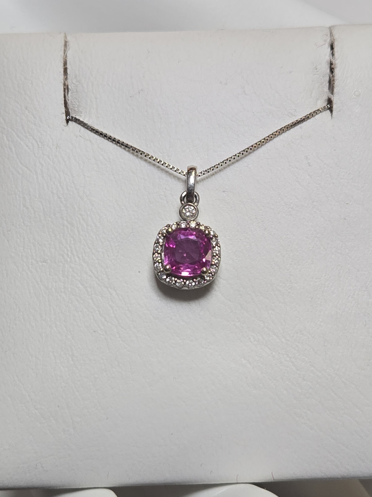 14K white gold pendant with a 1.05ct cushion-cut pink sapphire, showcasing elegant jewelry craftsmanship.