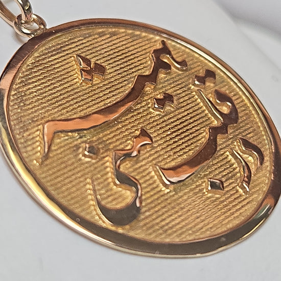 18K gold love pendant with intricate design, weighing 4.8g, from Chique Jewelry, displayed on a neutral background.