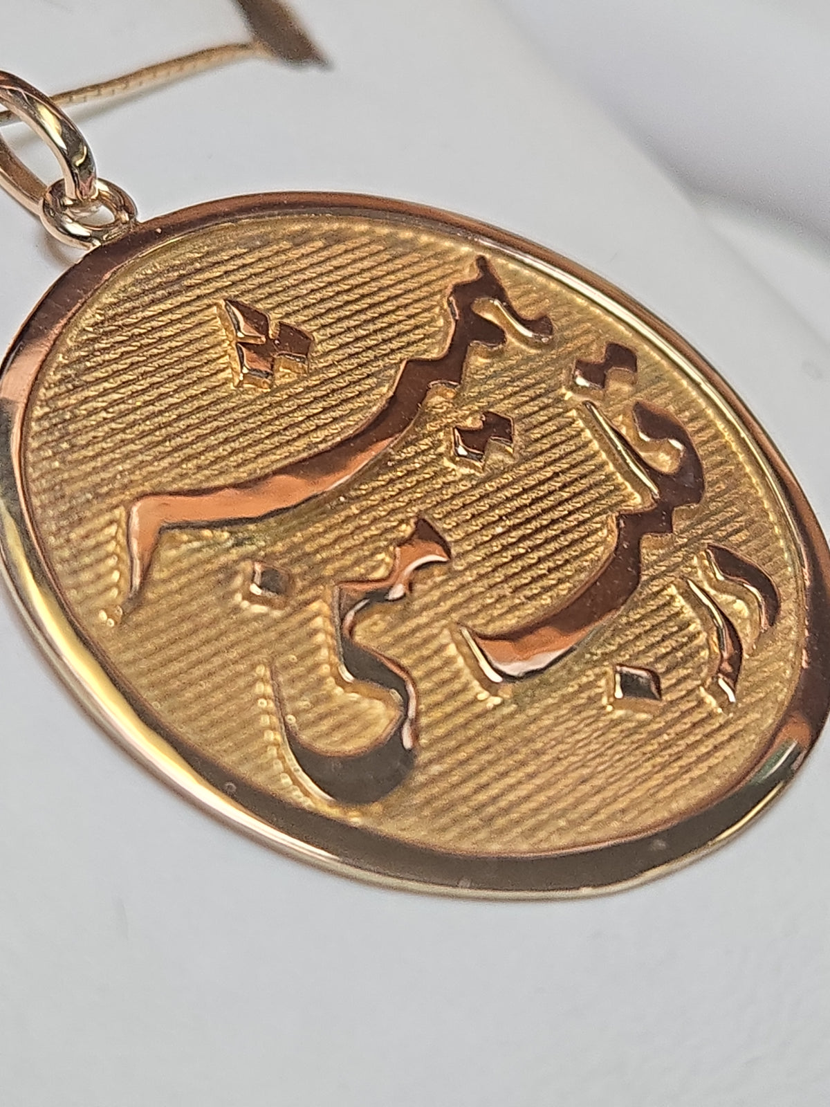 18K gold love pendant with intricate design, weighing 4.8g, from Chique Jewelry, displayed on a neutral background.