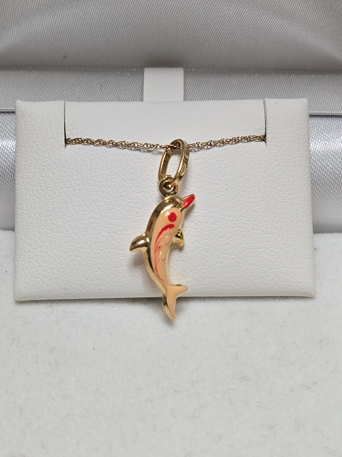 18K gold dolphin pendant weighing 0.8g, elegant jewelry piece by Chique Jewelry featuring a detailed dolphin design.