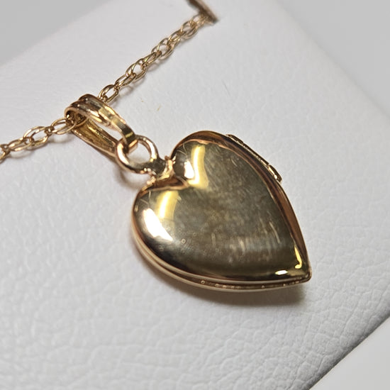 14K gold heart locket pendant by Chique Jewelry, featuring a delicate design and polished finish, weighs 1g.