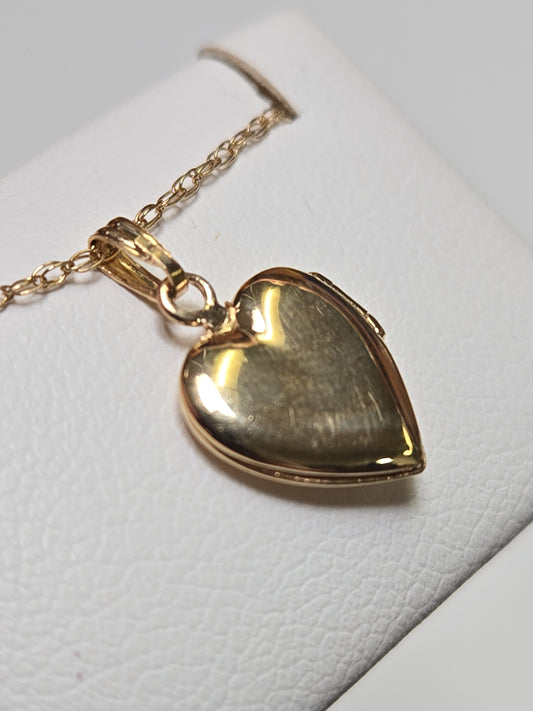 14K gold heart locket pendant by Chique Jewelry, featuring a delicate design and polished finish, weighs 1g.