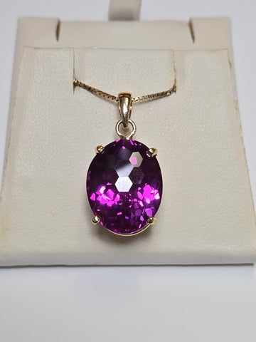 Oval 22ct lab-created alexandrite pendant in 10K gold, elegant jewelry piece with detailed design and vibrant gemstone.