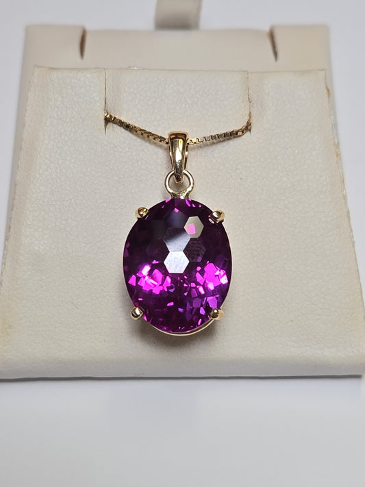 Oval 22ct lab-created alexandrite pendant in 10K gold, elegant jewelry piece with detailed design and vibrant gemstone.