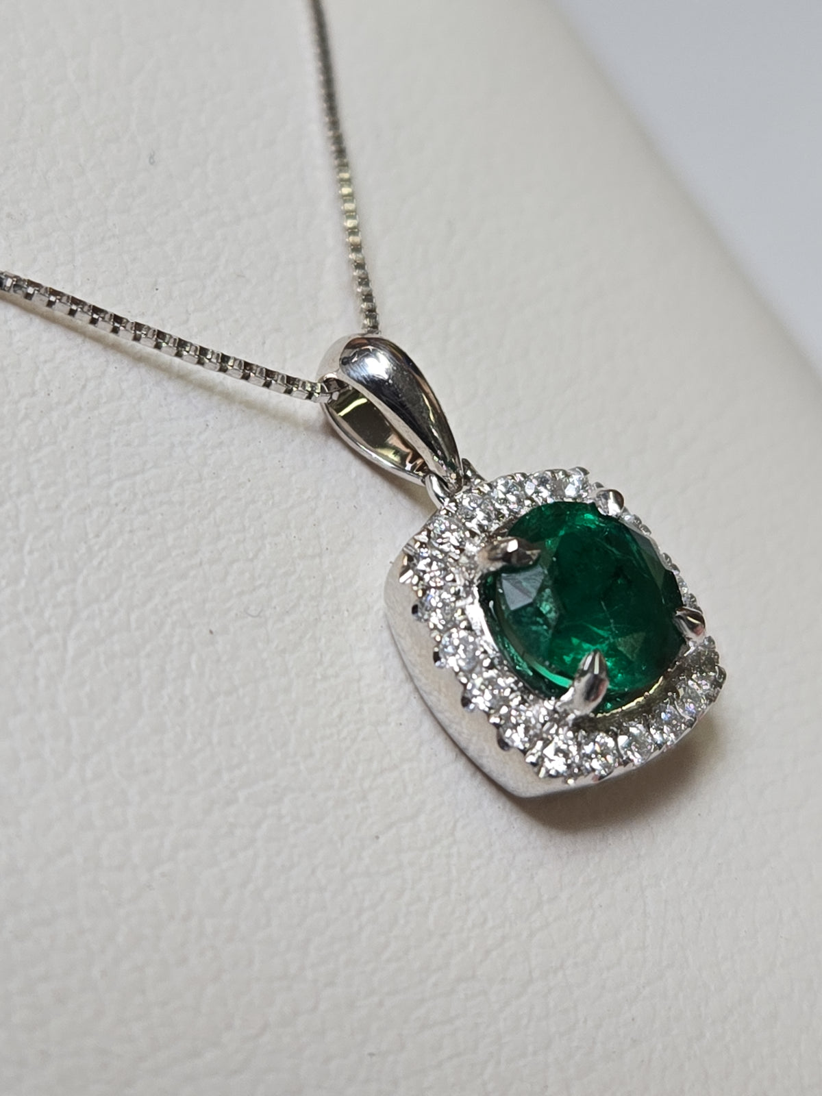 18K white gold pendant with a 0.76ct round emerald, weighing 1.6g, from Chique Jewelry.