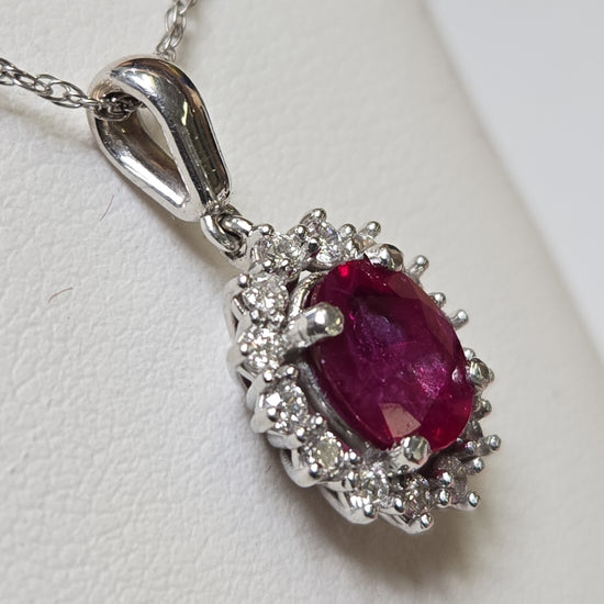 14K white gold pendant with 1.5ct oval ruby, featuring a delicate design and weighing 2.7 grams.
