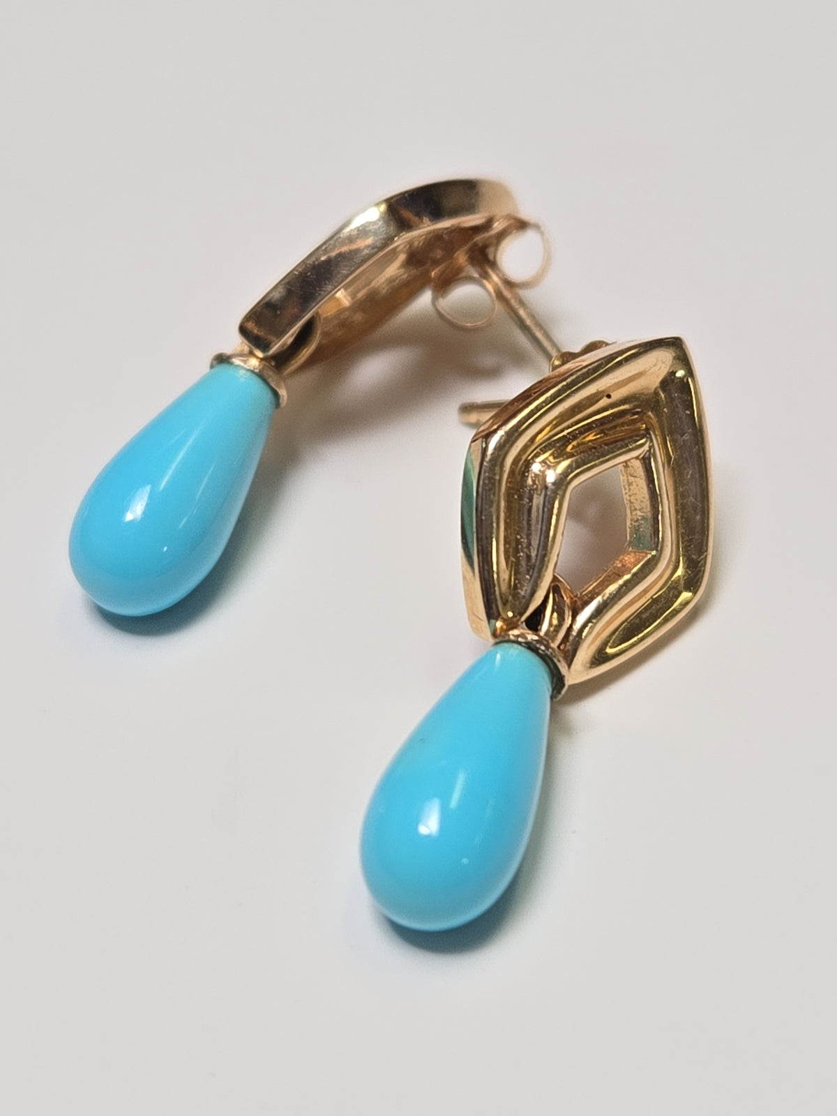 Pear-shaped turquoise drop earrings in 14K gold from Chique Jewelry, showcasing elegant jewelry design.