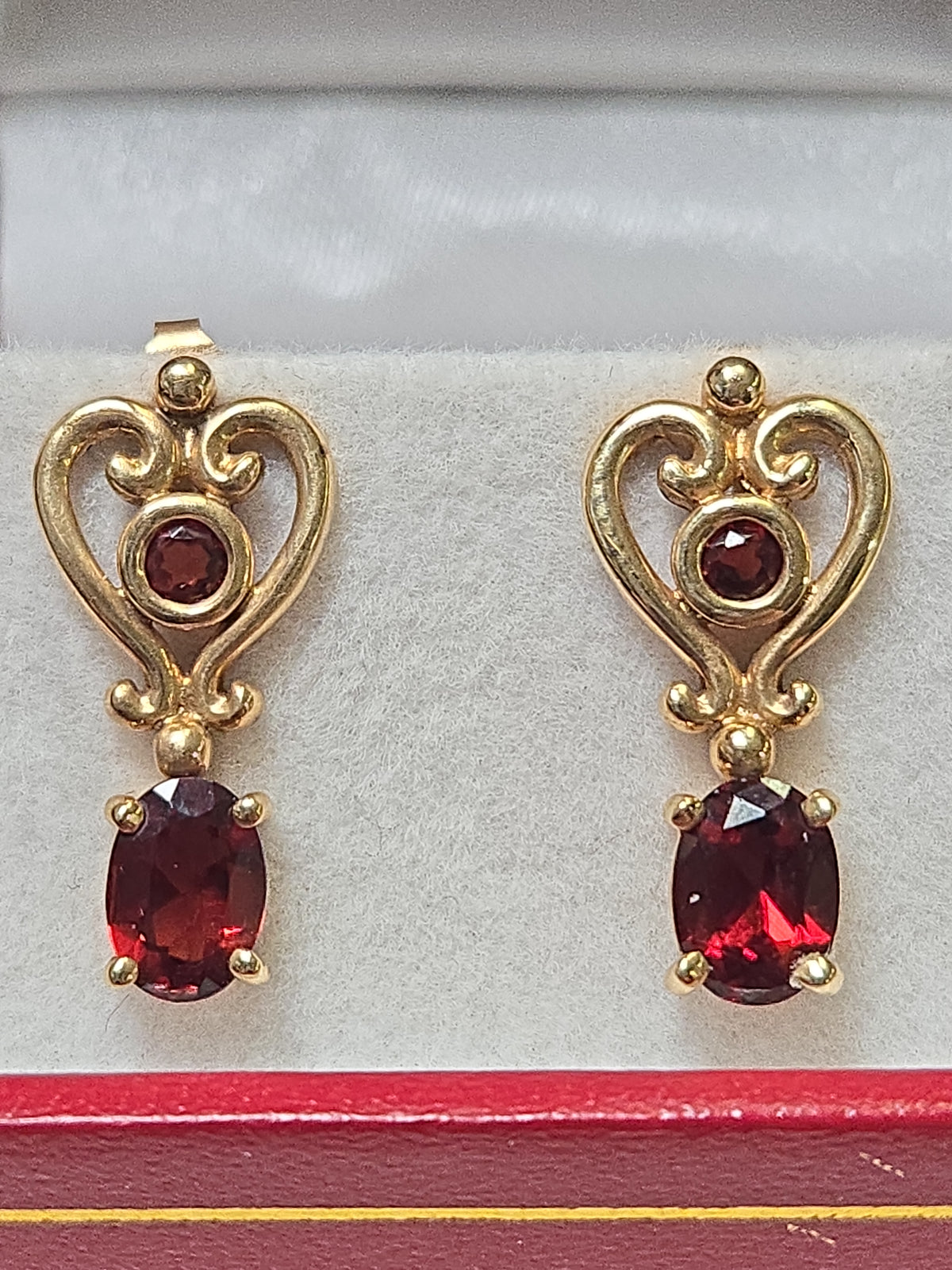 14K gold drop earrings with 2ct oval garnets, featuring elegant design and sparkling gemstone accents by Chique Jewelry.
